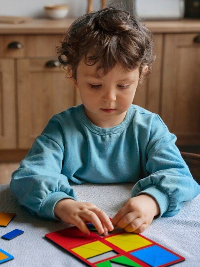 Happy child playing with puzzle pieces, symbolizing autism awareness and early signs detection.